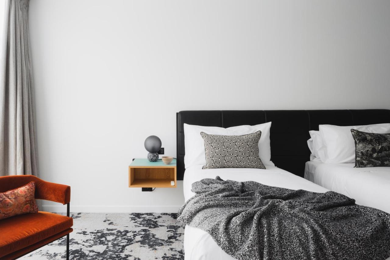 Ebb-Dunedin Exteriér fotografie A bedroom with a bed, a chair and a nightstand