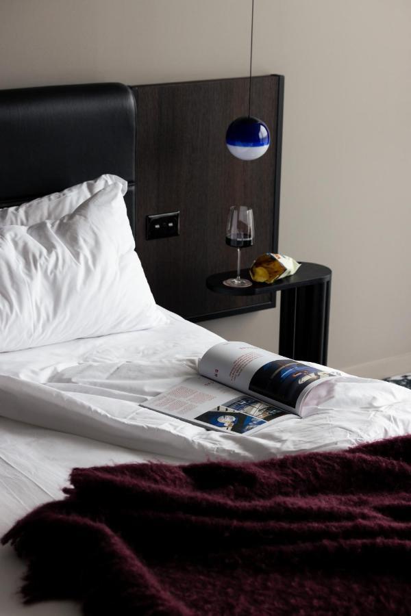 Ebb-Dunedin Exteriér fotografie A bed with a magazine and a wine bottle